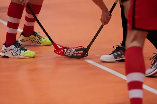 Männer die gerade Floorball spielen.