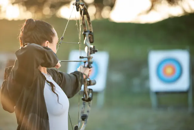 Sportarcher, Ziel-, Bogen- und Pfeiltrainings für Bogenschießen, sportliche Herausforderung oder Mädchenfeldübungen.