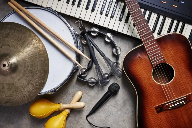 Eine Gruppe von Musikinstrumenten wie Gitarre, Trommel, Tastatur, Tambourine.