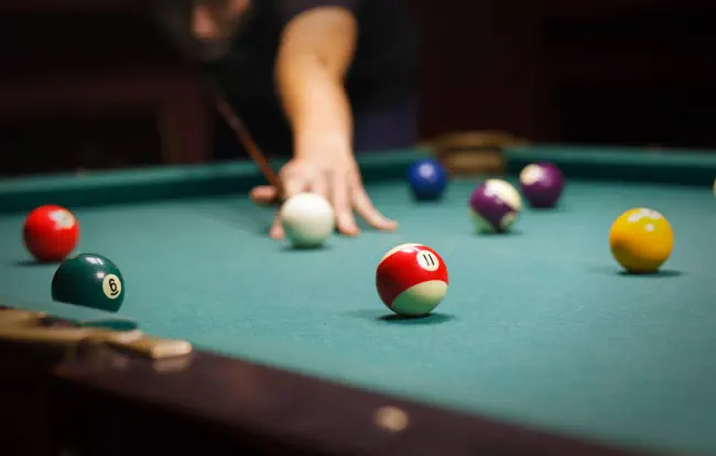 Person spielt Billard.
