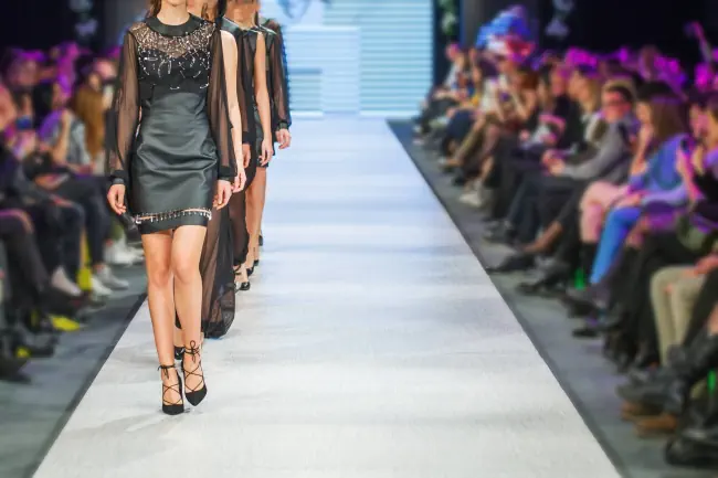 Modeschau mit vielen Models auf der Bühne.
