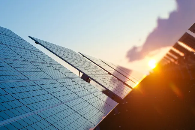 Schönes Bild von Solarpanele mit Sonnenuntergang im Hintergrund.