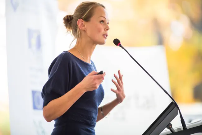 Hübsche junge Geschäftsfrau, die eine Präsentation in einem Konferenz-/Tagungsraum
