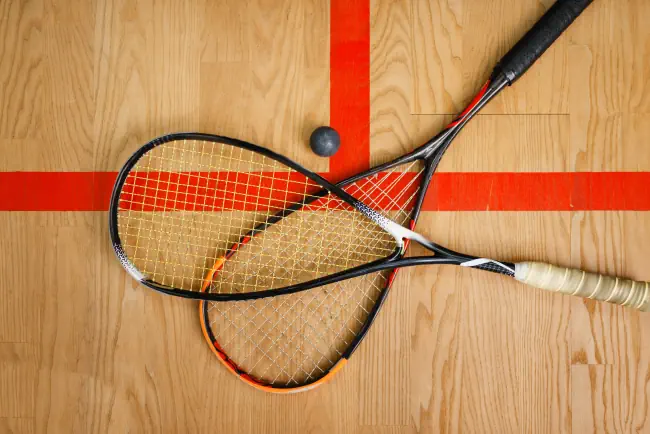 Squash-Schläger und Ball auf Hofboden, Draufsicht